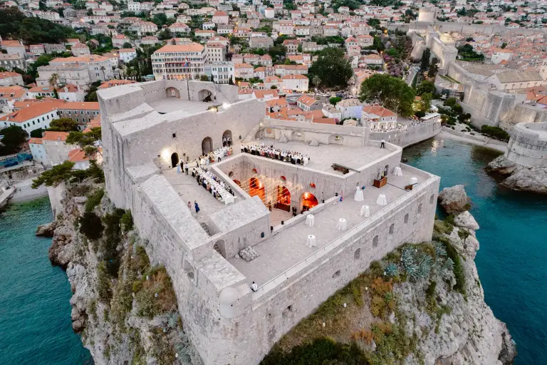 Destination wedding at St. Lawrence Fortress in Dubrovnik featuring a bride and groom above the historic city walls.