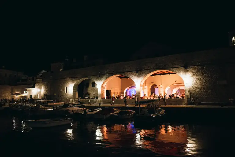Elegant wedding reception setup at Arsenal Restaurant in Dubrovnik, Croatia, featuring historic stone architecture, waterfront views, and romantic décor for a destination wedding celebration.