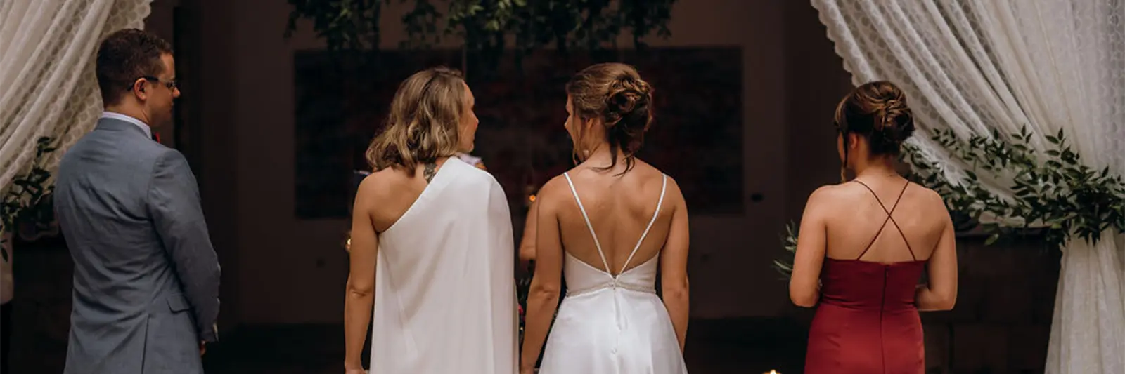 Two brides holding hands during an intimate same-sex wedding ceremony filled with love and joy